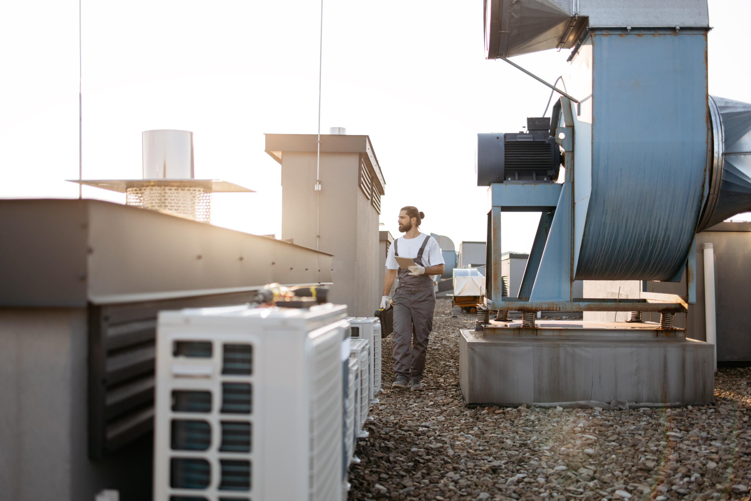 Technik HVAC sprawdzający instalacje na dachu